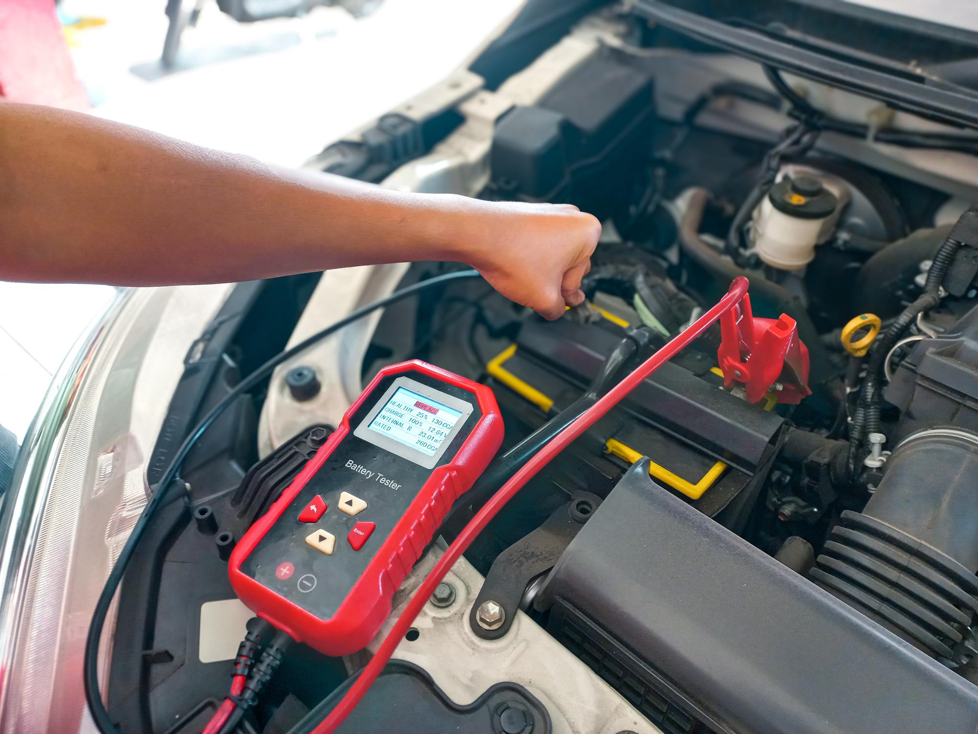 A technician testing out the battery of a vehicle